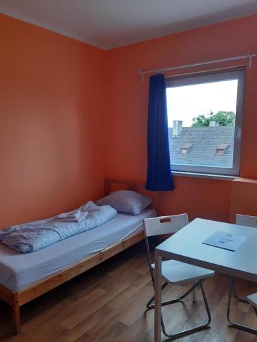 a bedroom with a bed and a window and a table at 2-Rent Group Hostel Rooms&Apartments TUB19A in Munich