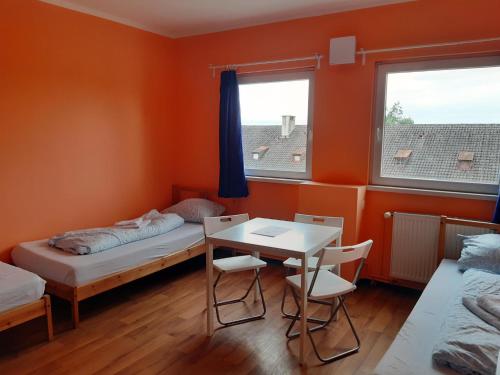 a room with two beds and a table and chairs at 2-Rent Group Hostel Rooms&Apartments TUB19A in Munich