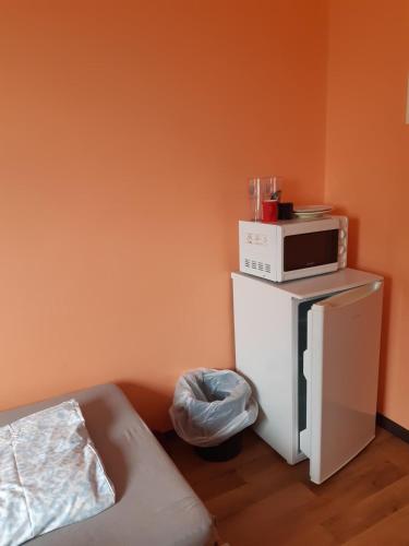 a room with a microwave on top of a refrigerator at 2-Rent Group Hostel Rooms&Apartments TUB19A in Munich