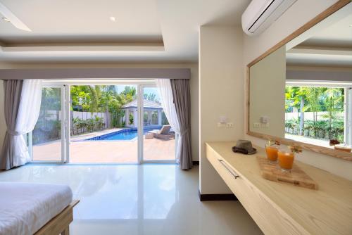 a bedroom with a bed and a large mirror at Baan Rim Talay in Nathon