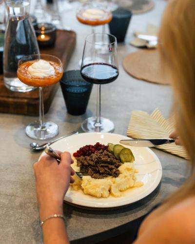 a woman sitting at a table with a plate of food at Polaris Villas in Muonio