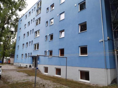 a blue building with windows on the side of it at 2-Rent Group Hostel Rooms&Apartments TUB19A in Munich