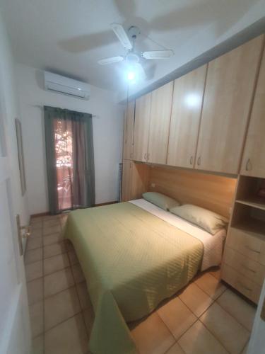a bedroom with a bed and a ceiling fan at La Bouganville in Villasimius