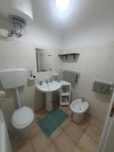 a bathroom with a toilet and a sink at La Bouganville in Villasimius