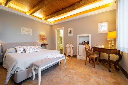 a bedroom with a bed and a table and a desk at La Foresteria di Serracavallo in Bisignano