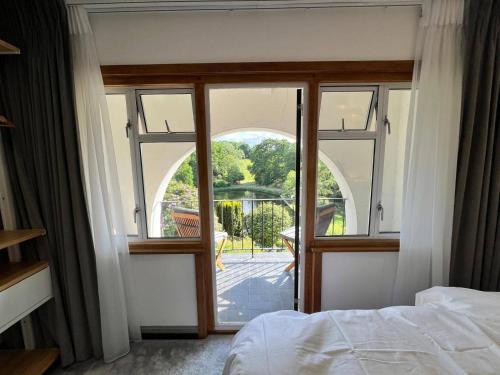 a bedroom with a large window with a view at 5 Bedroom Lake House in a nature reserve in Devizes