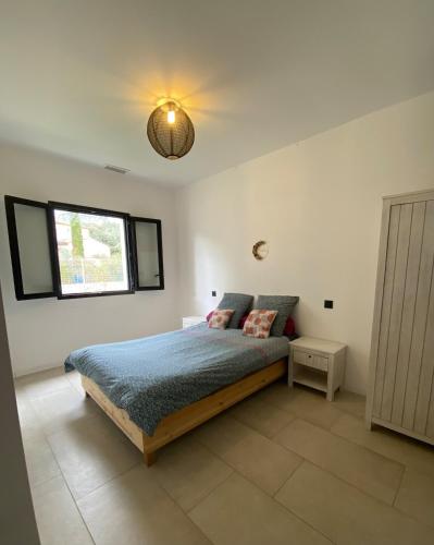 une chambre avec un lit et une lumière au plafond dans l'établissement Charmante maison à Garrigues St-Eulalie, à Collorgues