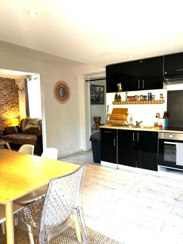 Il comprend une cuisine et un salon avec une table en bois. dans l'établissement Le Bohème 3 pièces jardin, à Saint-Laurent-du-Var