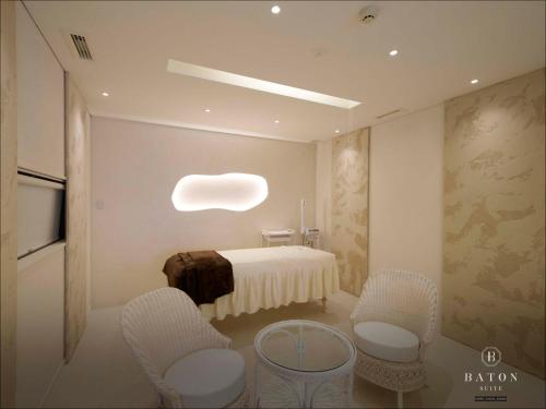 a room with a bed with chairs and a table at BATON SUITE Okinawa-kourijima in Nakijin