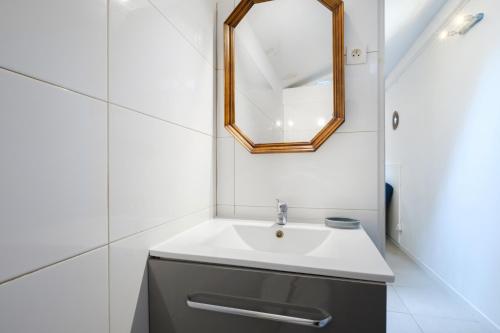 une salle de bain avec un lavabo et un miroir dans l'établissement Studio - Le Vernier, à Nice