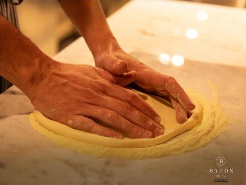 a person kneading a dough on a counter at BATON SUITE Okinawa-kourijima in Nakijin