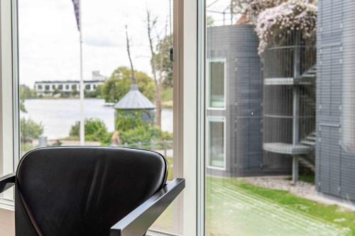 a black chair sitting in front of a window at Kolding Hotel Apartments in Kolding