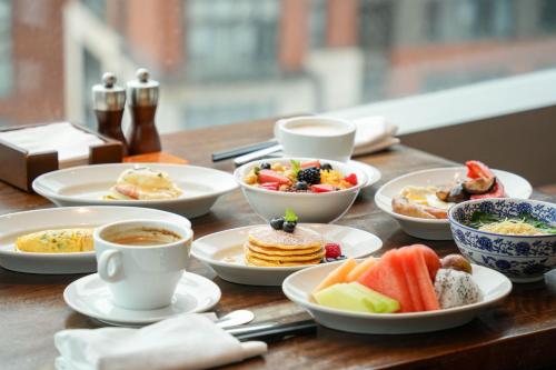 a table with plates of food and cups of coffee at Grand Hyatt Shenzhen in Shenzhen