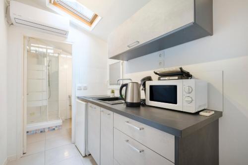 une cuisine avec un four micro-ondes sur un comptoir dans l'établissement Studio - Le Vernier, à Nice