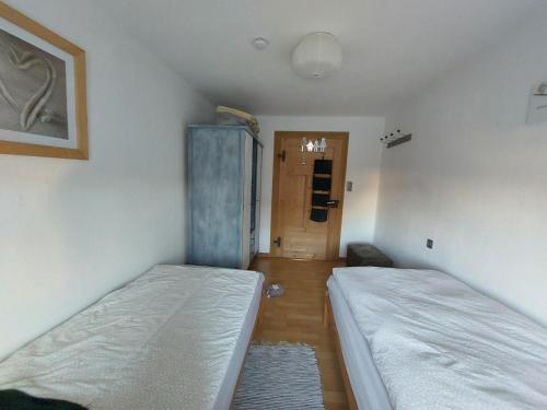 a room with two beds and a hallway with a door at Ferienwohnung - Das Boarding House in Lemgo