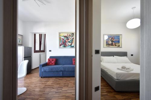 Una sala de estar con un sofá azul y una cama. en Akoya Lux Shore - YourPlace Abruzzo, en Torino di Sangro