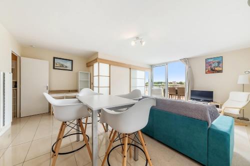 un salon avec un lit, une table et des chaises dans l'établissement La Terrasse - Vue Mer - au coeur de Dinard, à Dinard