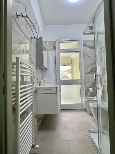 a bathroom with a sink and a toilet and a window at Villa Solaris in Sanremo