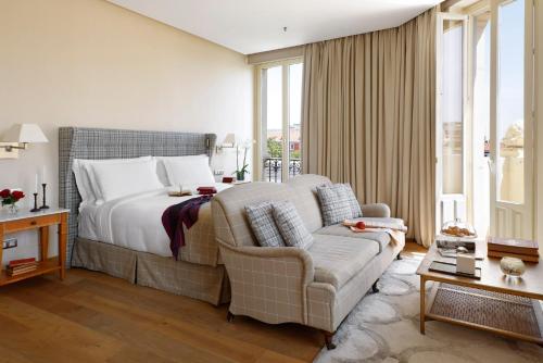 a bedroom with a bed and a couch and a chair at URSO Hotel & Spa, a Small Luxury Hotel of the World in Madrid