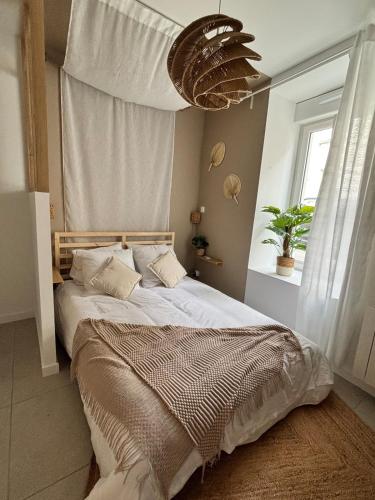 a bedroom with a large bed with a large window at La parenthèse balinaise in Cholet
