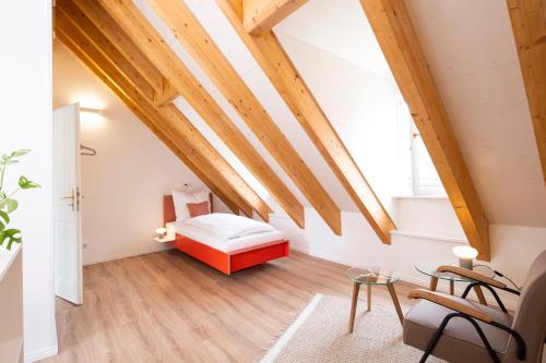 バンベルクにあるBunter Hund Apartments - ganzes historisches Altstadthausの木製の天井が特徴の屋根裏のベッドルーム1室(ベッド1台付)