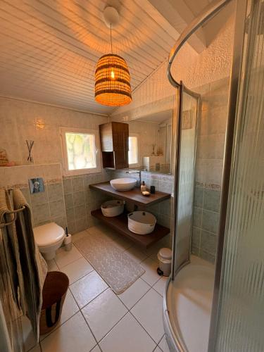 La salle de bains est pourvue d'une douche, de 2 toilettes et d'un lavabo. dans l'établissement LUMIO Élégance & Calme absolu avec piscine et vue mer, à Lumio