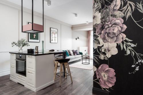 a kitchen and a living room with a kitchen island and a living room with at Neptun Park Premium by NorthSide Apartments in Gdańsk