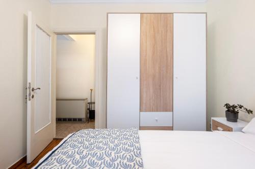 a bedroom with a white bed and a large mirror at Houseloft Seaside Getaway in Thessaloniki