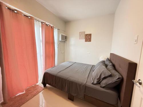 een slaapkamer met een bed en een groot raam bij Lecels Haven Place in Dauis