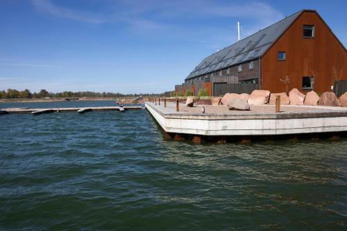 a barn on the water next to a building at Varvet Sea View Suites by Ålandhotels in Mariehamn