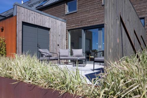 a patio with chairs and tables on a building at Varvet Sea View Suites by Ålandhotels in Mariehamn