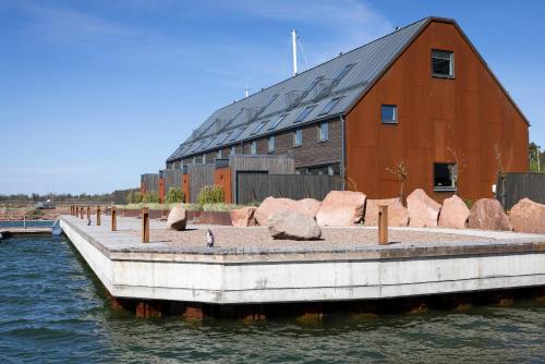 a barn sitting on the water next to a dock at Varvet Sea View Suites by Ålandhotels in Mariehamn