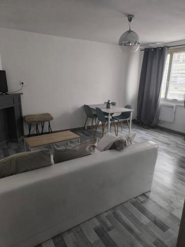 a living room with a couch and a table at appart 2 proche plage in Bray-Dunes