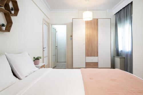 a bedroom with a large white bed and a window at Houseloft Seaside Getaway in Thessaloniki