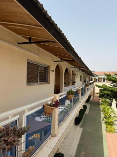a balcony of a house with potted plants on it at TRANQUIL RESORT HOTEL in Brusubi