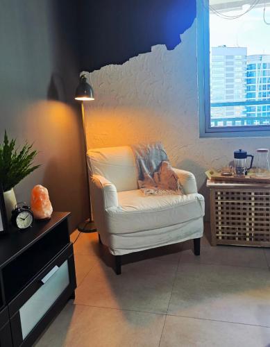 a white chair sitting in a room with a wall at QuiHouse in Manila