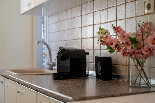 a kitchen counter with a toaster and a vase of flowers at Houseloft Seaside Getaway in Thessaloniki