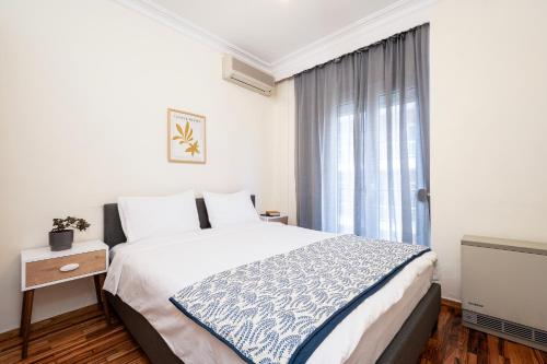 a bedroom with a large bed and a window at Houseloft Seaside Getaway in Thessaloniki