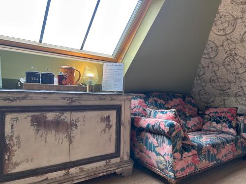 an old couch and a chair in a room with a window at Saskia's Rooms in Winchester