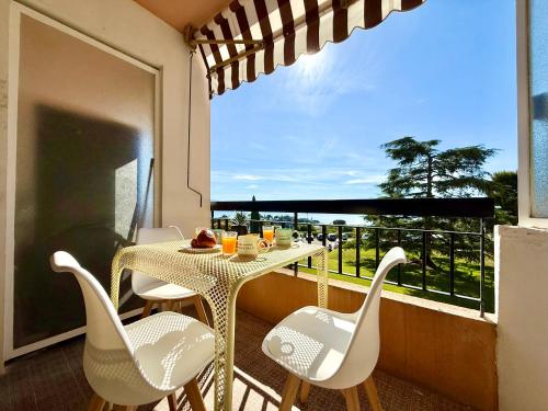 un balcon avec une table, des chaises et une fenêtre dans l'établissement CHARMILLES - Agréable 3 pièces - Parking gratuit- Proche Monaco, à Roquebrune-Cap-Martin
