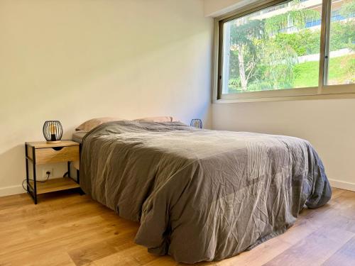 une chambre avec un lit et une fenêtre dans l'établissement CHARMILLES - Agréable 3 pièces - Parking gratuit- Proche Monaco, à Roquebrune-Cap-Martin