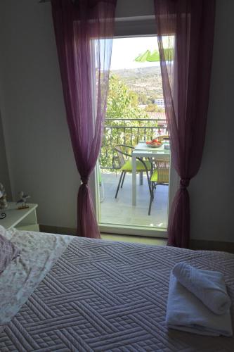 a bedroom with a bed and a balcony with a table at Maris Rogoznica in Rogoznica