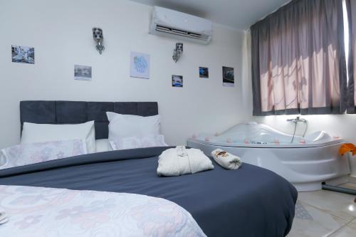 a bedroom with a tub and a bed with towels at Luxury Panorama pyramids & jacuzzi in Cairo