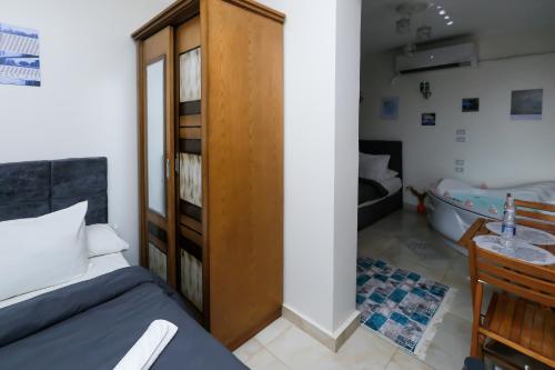 a bedroom with a bed and a wooden cabinet and a tub at Luxury Panorama pyramids & jacuzzi in Cairo