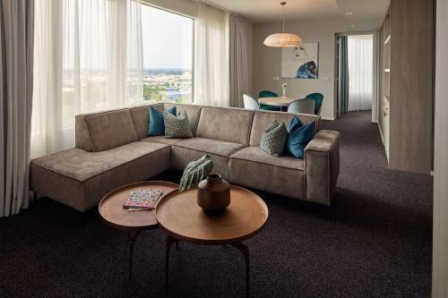 a living room with a couch and a table at Van der Valk Hotel Tiel in Tiel