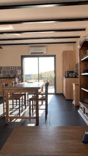 une salle à manger avec une table et une grande fenêtre dans l'établissement Gîte charme et nature Drôme, à Chantemerle-les-Blés