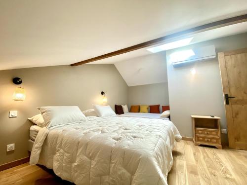 Un dormitorio con una gran cama blanca en una habitación. en Gîte charme et nature Drôme, en Chantemerle-les-Blés