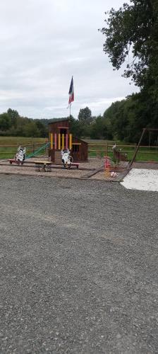 un parc avec une aire de jeux, un bâtiment et un drapeau dans l'établissement emplacement pour toile de tente, à Beaufay