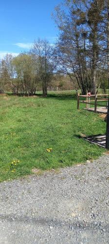 un parc avec une clôture et un champ d'herbe dans l'établissement emplacement pour toile de tente, à Beaufay