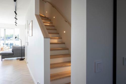 a staircase in a house with white walls and wooden floors at Varvet Sea View Suites by Ålandhotels in Mariehamn